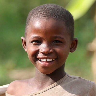 Kind mit kurzem Haar lächelt glücklich – Sinnbild für Gesundheit und Hoffnung dank sauberem Trinkwasser.